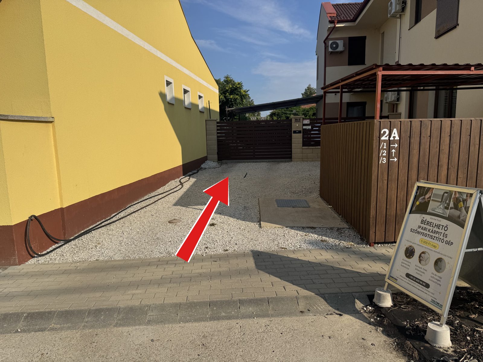 ToolTime gépkölcsönző bejárata Mikepércsen, a piros nyíl a hátsó ház felé mutat
